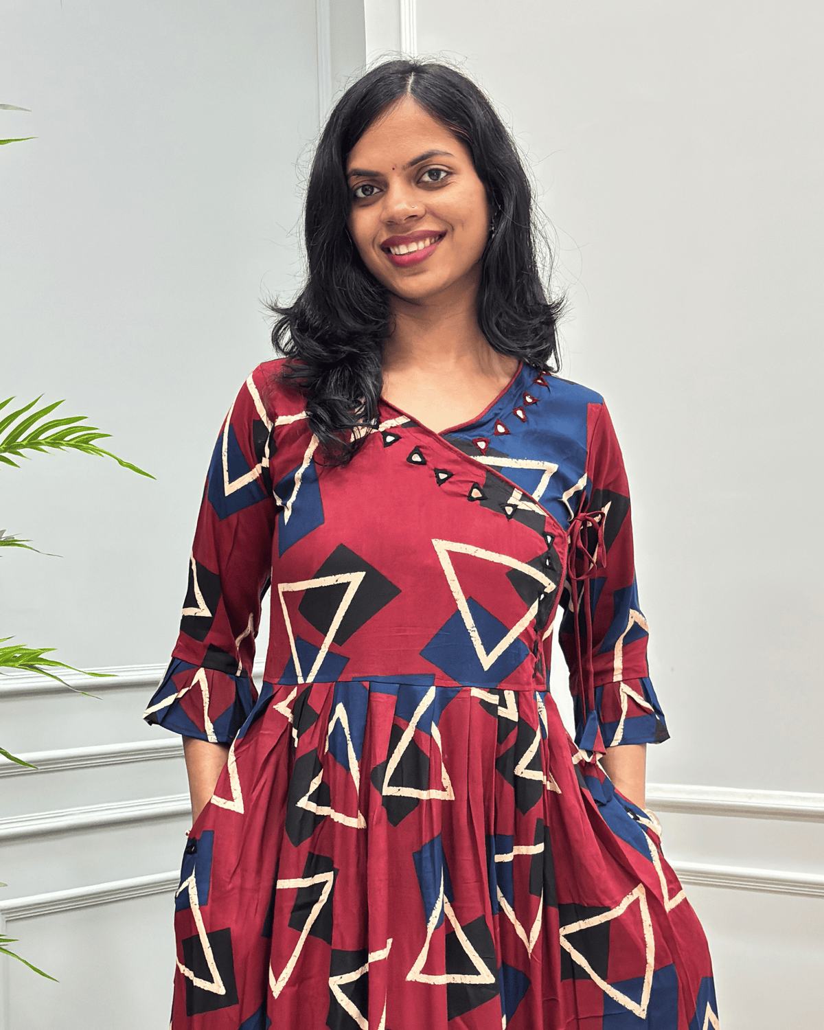 Close-up of Red women's vegetable dyed cotton long-kurti featured with hand-mirror work on V shaped-neck border, frill sleeves on calf.
