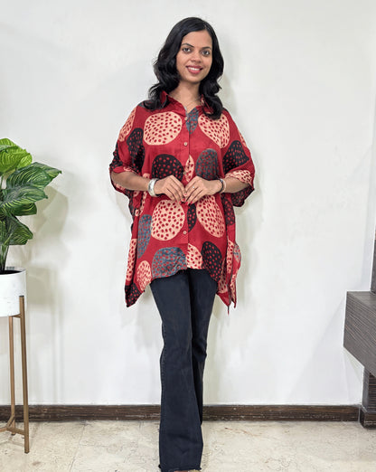 Red Women's Ajrakh pure Mashru Silk Short Kaftan Shirt with a bold abstract of pink, black, and red geometric circles print, paired with dark pants, standing in front of a white wall.