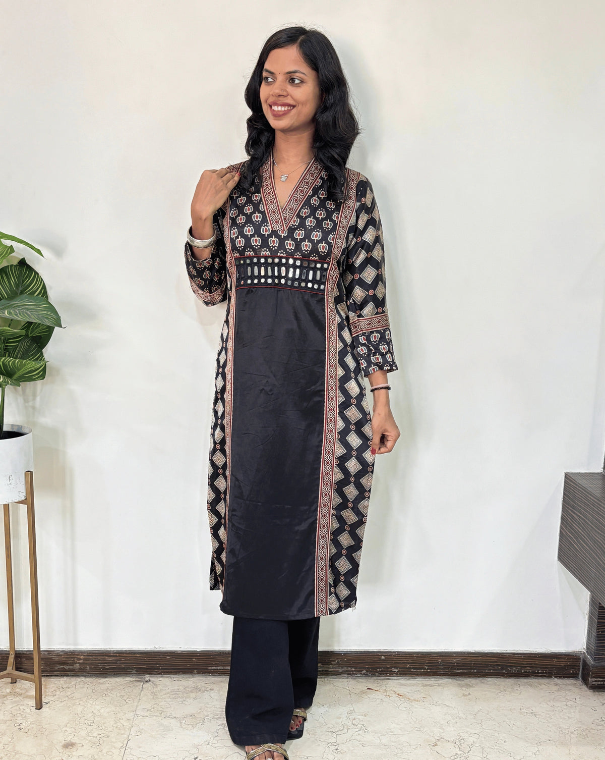 Black Woman's Ajrakh Pure Mashru Silk Long-Kurti with Ajrakh print panel- border on front & Sleeves cuffs, patterned dress with a yellow center against a white wall