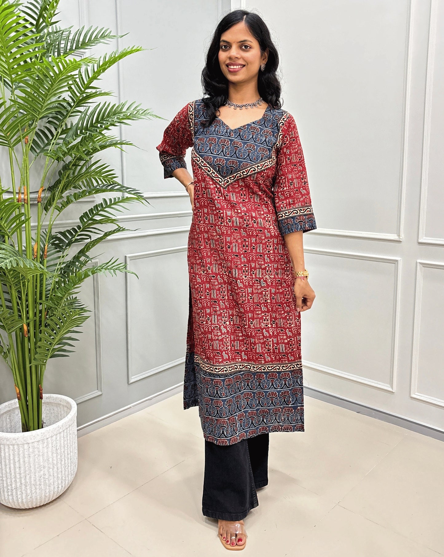 Front View of Red Hand-block cotton kurti with black - beige border &  Ajrakh print on front and sleeves, paired with black flared jeans 