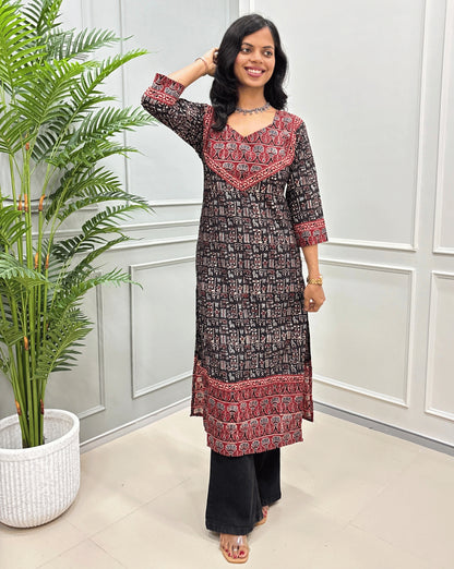 Front View of Black Hand-block cotton long- kurti with red border &  Ajrakh print on front and sleeves, paired with black flared jeans 
