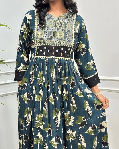 Close-up of Green Ajrakh Plant based cotton Long-kurti featured with three-quarter sleeves , Ajrakh print on curved V-neck-line , hand-mirror work on front chest & sleeves cuffs, Beautiful leaf print on dress along with pocket.