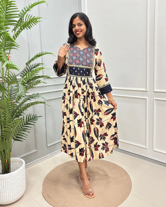 Beige Women's Ajrakh vegetable dyed Rayon Cotton Long-kurti with Three-quarter Sleeves , colorful geometric print on neck and ajrakh border print on front & sleeves , standing in front of grey wall.
