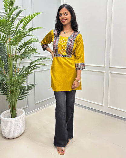 Yellow women's cotton Ajrakh short kurti front view with a colorful patterned embroidery on the neckline ajrakh print on sleeves cuffs. 