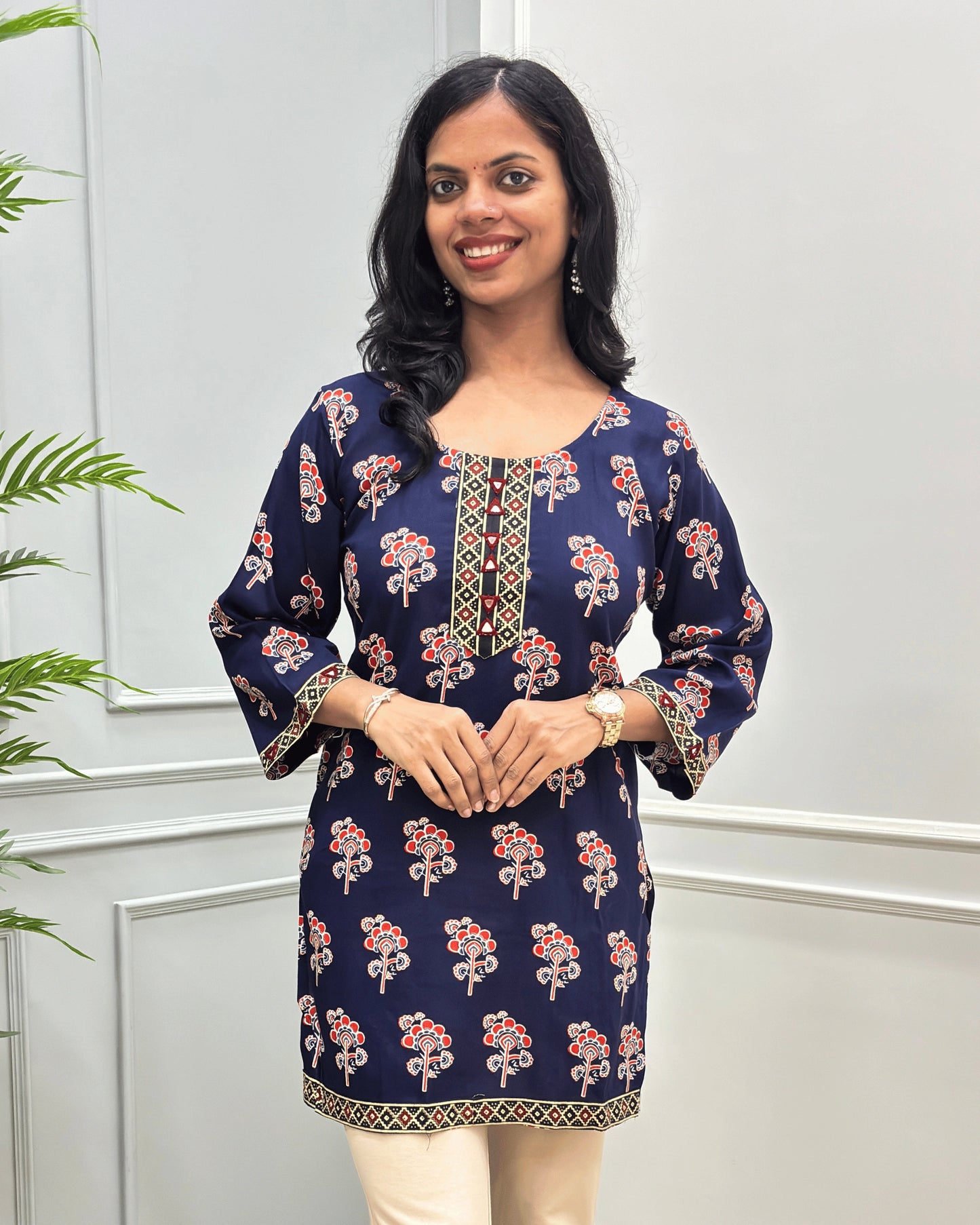 Close-up of Navy-Blue women's cotton Short kurti featuring a Floral printed patterned with ajrakh print on neckline, bottom, sleeves cuffs, hand-mirror work on Round-neck .