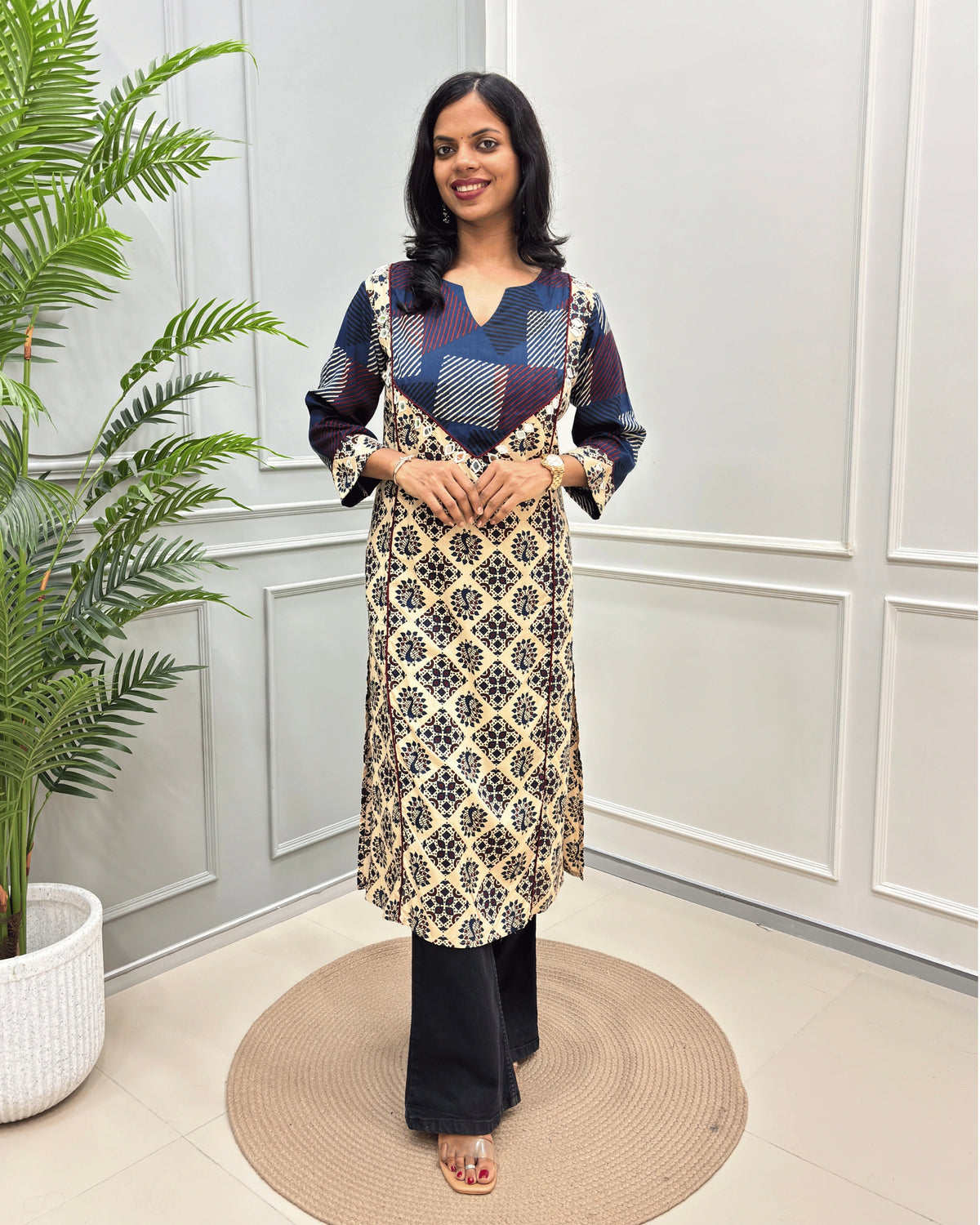Beige Women's Vegetable dyed plant based cotton Straight Long-kurti featured strip print on blue base on front and half sleeves with peacock print from top-bottom on sleeves, standing in front of white wall and a potted plant .