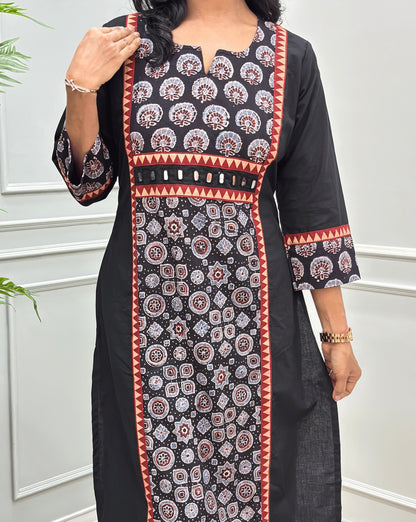 Close-up of Black Ajrakh Hand-block cotton long-kurti featuring hand-mirror work on front like a belt, geometric print below the mirror work in panel , V-shaped round neck-line.