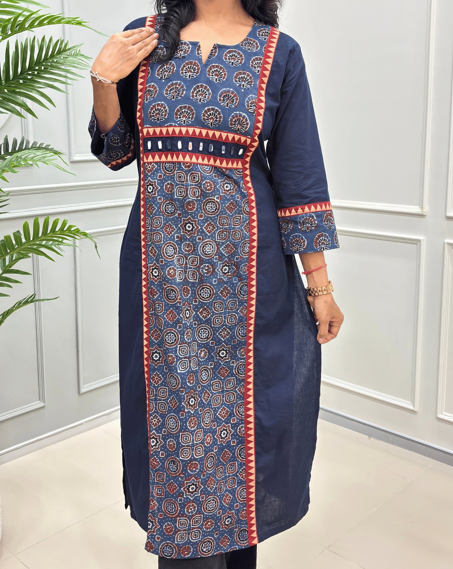 Close-up of navy blue hand-block cotton long-kurti featuring Round-v neck with floral & geometric ajrakh print on front and sleeves with hand-mirror embroidery on waist.