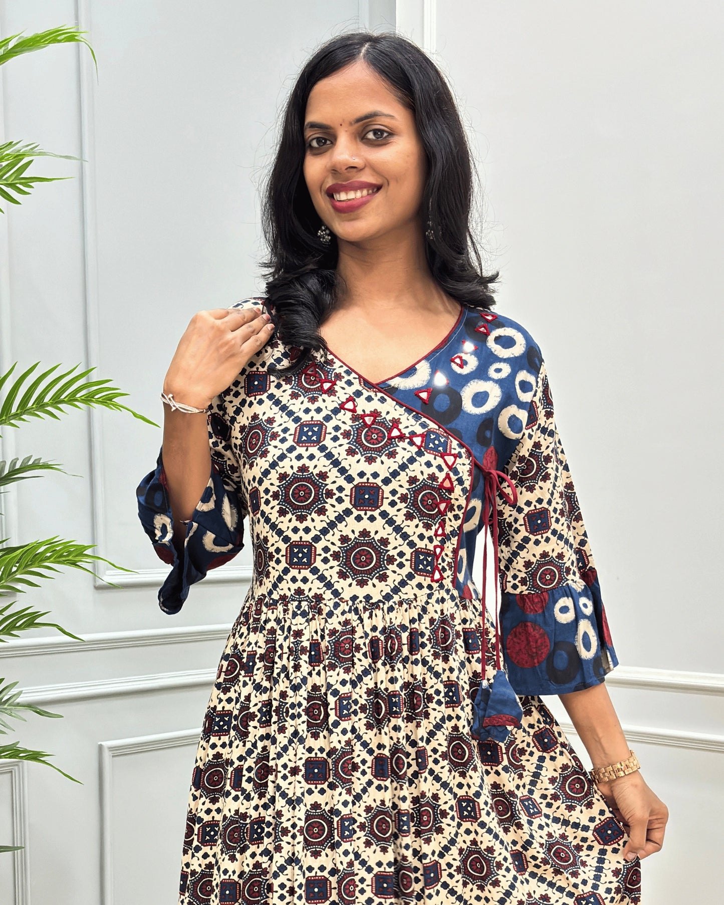 Close-up of Beige women's vegetable dyed cotton long-kurti featured with hand-mirror work on V shaped-neck border, frill sleeves on calf.