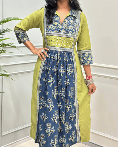 Close-up of Green Ajrakh plant based cotton long-kurti consisting a lime green colour and a matching blue floral printed frill.  blue and gold printed yoke panel, three-quarter sleeves with matching prints, and a hand-mirror work waistband, Collar V-neck .