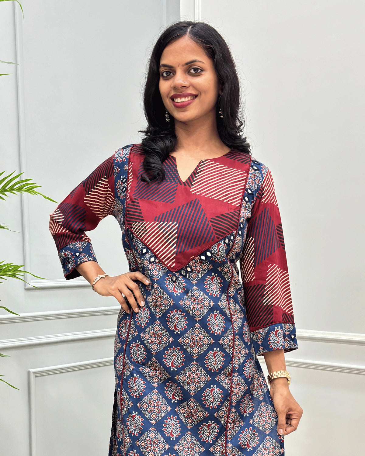 Close-up of Blue women's Vegetable dyed cotton long-kurti featured with V-shaped neck & yoke on front , hand-mirror wok on yoke border& sleeves calf.