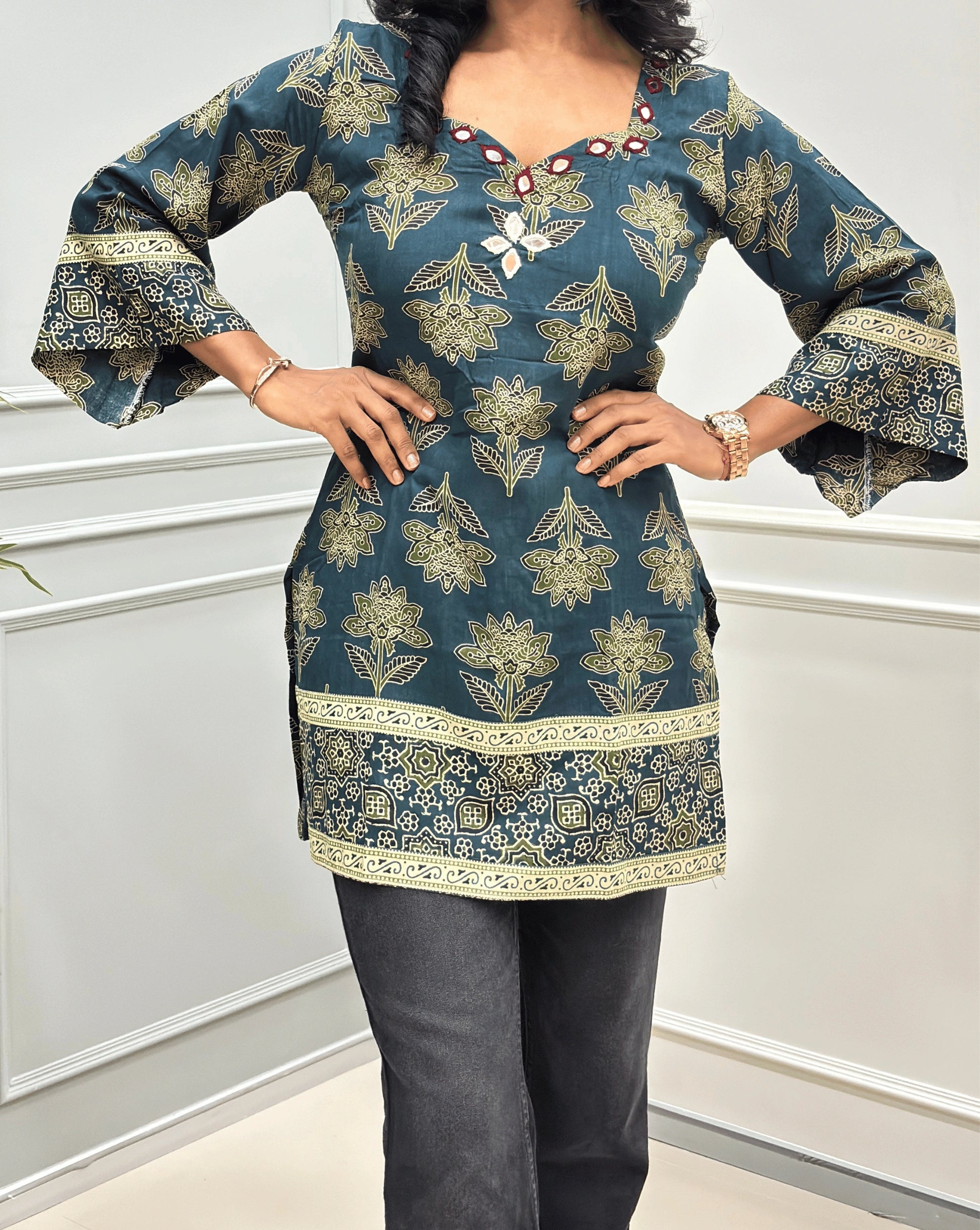 Close-up of  Green Ajrakh cotton kurti with hand-mirror embroidery on neck-line, & ajrakh print on three-quarter bell-sleeves .