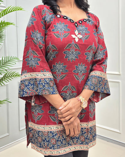 Side view of Red short cotton Ajrakh kurti featuring a detail three-quarter sleeves & decorative Ajrakh print border, hand-mirror work at neck-line & chest.
