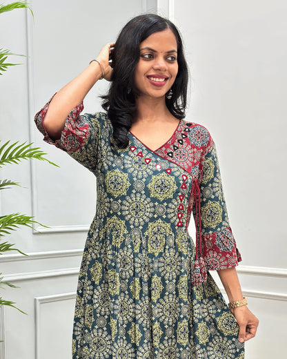 Close-up of Green-Red woman's Cotton Long-Kurti with three-quarter Frill sleeve, Hand-mirror work on  V-neck. a multicolor floral mandala print. The dress features a dark teal base with yellow, red, and white patterns, 