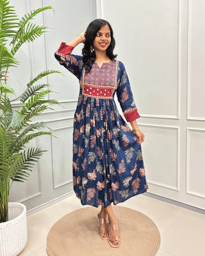 Blue Women's Ajrakh vegetable dyed Rayon Cotton Long-kurti with Three-quarter Sleeves , colorful geometric print on neck and ajrakh border print on front & sleeves , standing in front of grey wall.