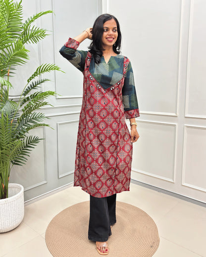 Red Women's Vegetable dyed plant based cotton Straight Long-kurti featured strip print on Green base on front and half sleeves with peacock print from top-bottom on sleeves, standing in front of white wall and a potted plant .